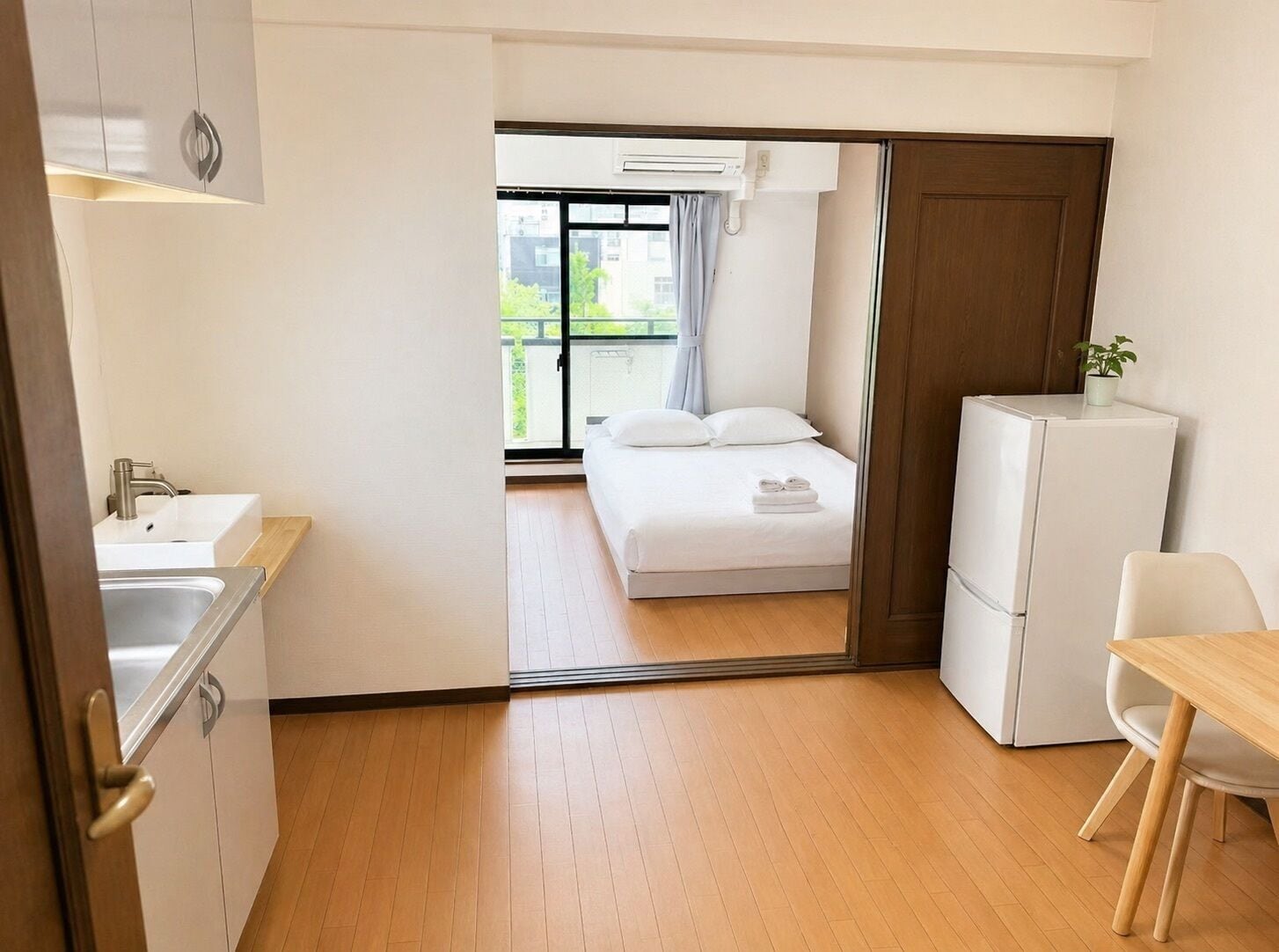 Una camera d'albergo con un letto, un angolo cottura, un'area ristoro e vista sull'esterno.