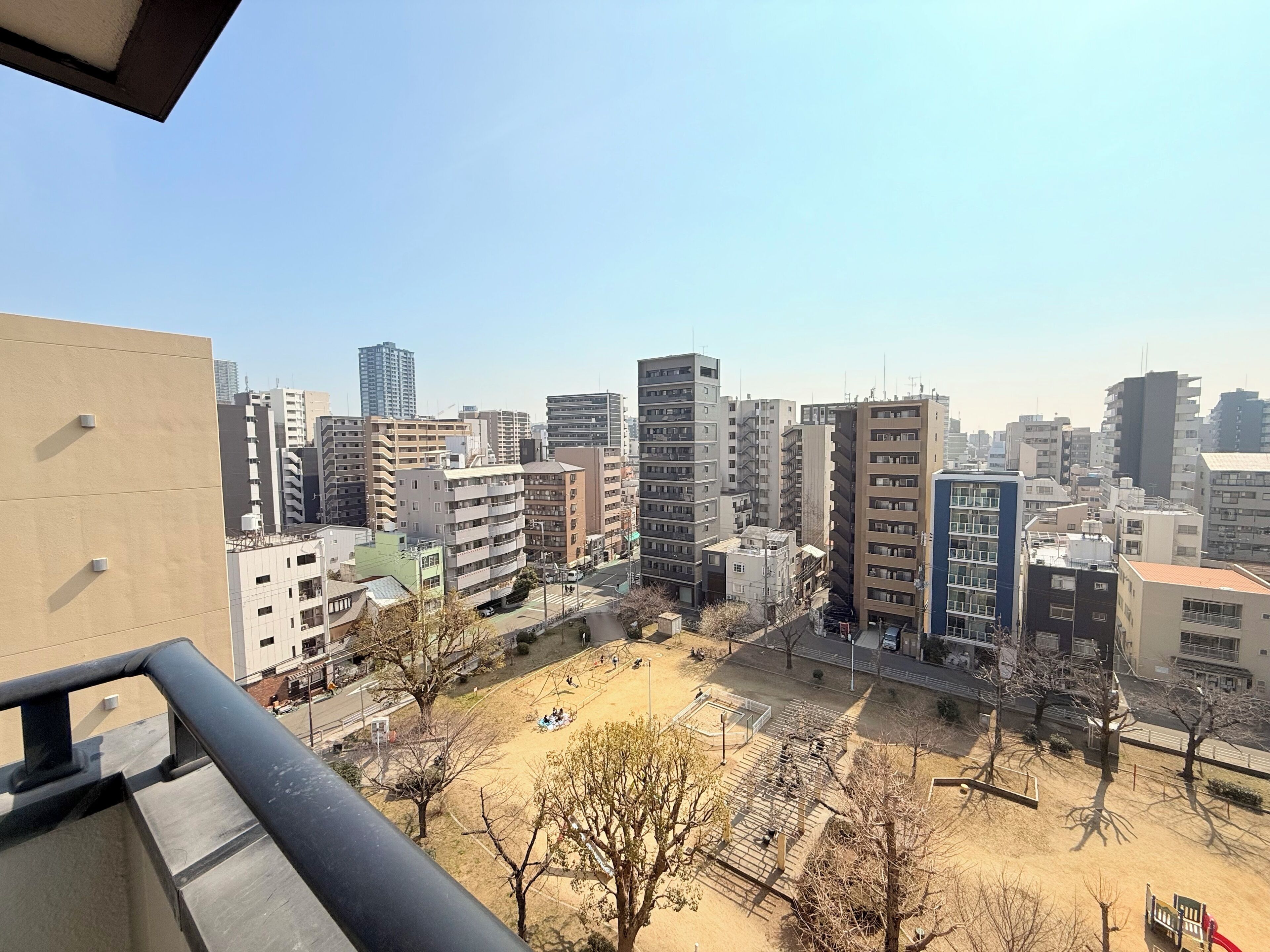 Panorama urbano con grattacieli, un'area giochi e cielo sereno.