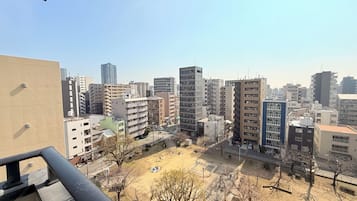 A cityscape with high-rise buildings, a playground, and a clear sky.