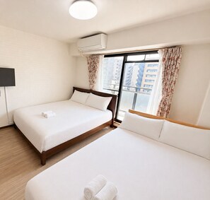 A hotel room with two beds, a flat-screen TV, an air conditioning unit, and a window with curtains. - Raku Osaka Daikokucho Namba Shinsaibashi (Osaka)