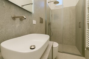A modern bathroom with a freestanding bathtub, a glass-enclosed shower, and a wall-mounted towel rack. - Fagales Apartment between Sorrento and Positano (Massa Lubrense)