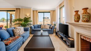 Una sala de estar moderna con un conjunto de sofás, una mesa de centro, un televisor y una chimenea.