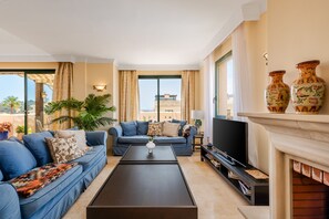 Ein modernes Wohnzimmer mit einer Sofagarnitur, einem Couchtisch, einem Fernseher und einem Kamin.