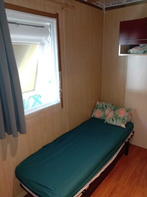 A small, single-bed room with a window, a curtain, and a wooden floor. - Cozy chalet on the banks of the Blavet River, near hiking trails (Pluméliau-Bieuzy)