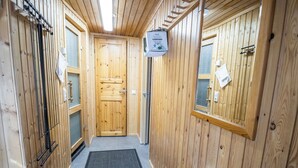 A wooden interior hallway with a sauna sign, a door, and a window with a view. - Nelostupa a by Interhome (Ylläsjärvi)