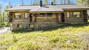 A log cabin with a stone foundation, multiple windows, and a chimney. - Nelostupa a by Interhome (Ylläsjärvi)