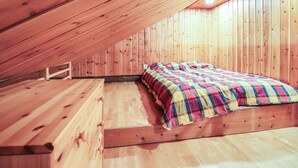 Un dormitorio abuhardillado con cama y banco.