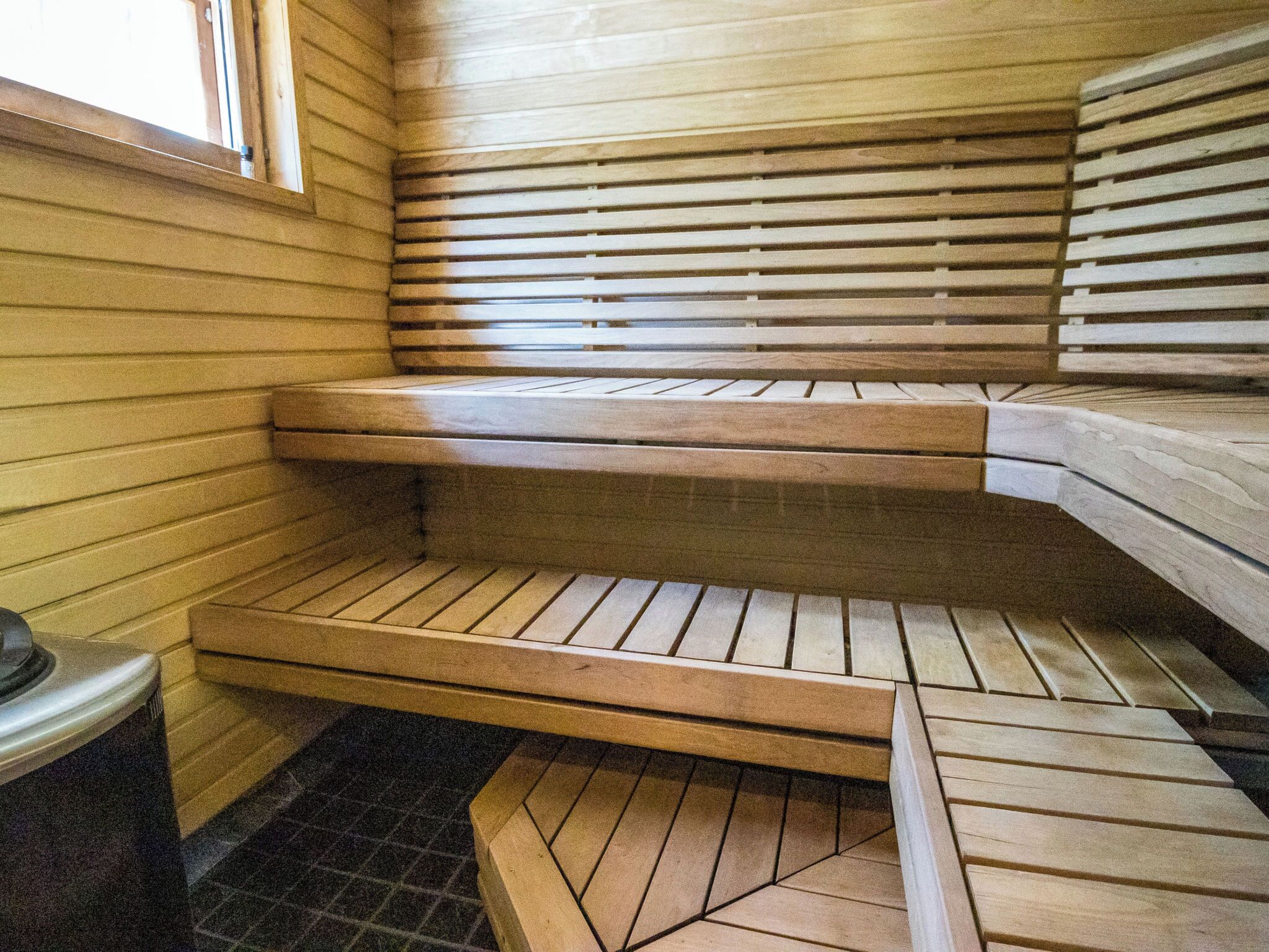A sauna with wooden benches and a tiled floor.