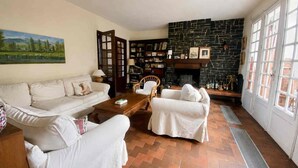 A living room with a fireplace, a sofa set, a bookshelf, and a painting on the wall. - Large family home in Bagnères-de-Bigorre (Bagnères-de-Bigorre)