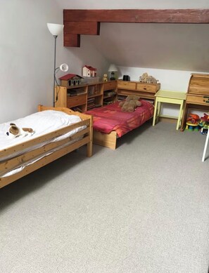 A child's bedroom with a bunk bed, wooden furniture, and toys.