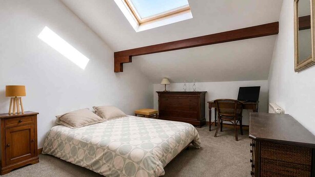 A bedroom with a bed, a desk, a chair, a dresser, and a skylight. - Large family home in Bagnères-de-Bigorre (Bagnères-de-Bigorre)