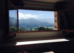Una habitación con un amplio ventanal con vistas a un paisaje montañoso.