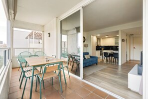 A modern apartment with a dining area, kitchen, and living space. - Bright 2-bedroom apartment for 4 with a furnished terrace, distant sea views, two bathrooms, pools, gardens, playground and two shared padel courts near Diagonal Mar. (Barcelona)
