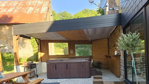 A covered outdoor area with a hot tub, picnic table, and a potted plant. - Charming, peaceful vacation rental with a spa, near the beaches (Ver)