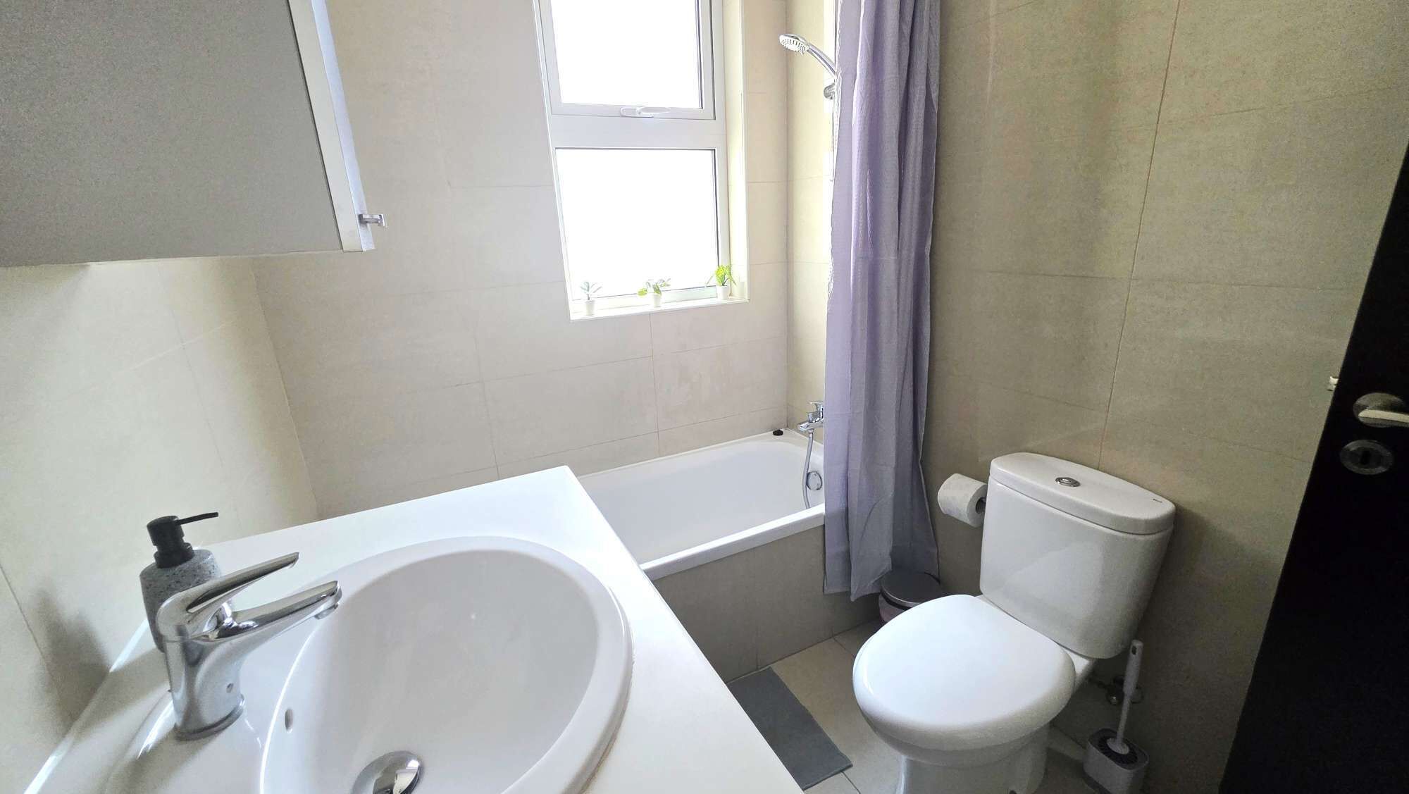 A bathroom with a bathtub, toilet, and sink.