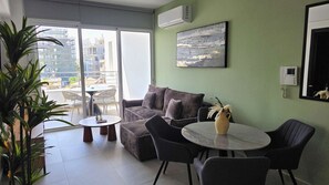 A modern living room with a sofa, chairs, a small table, and a potted plant. - Modern Apartment • Peaceful Retreat • Nature Views (Larnaca)