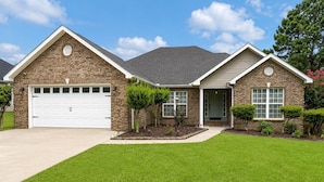 A two-story house with a garage, a front door, and a well-maintained lawn. - In-ground Pool | 5BR | Family Friendly (Warner Robins)