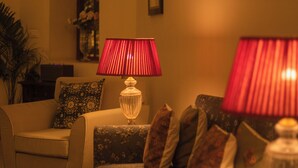 Una sala de estar con sofá, sillón, lámpara y alfombra.