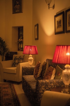 A living room with a sofa, a chair, a lamp, and a rug.