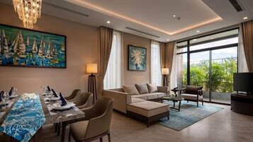 A modern living room with a dining area, a sofa set, a chandelier, and a large window with a view.