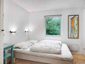 Ein Schlafzimmer mit einem Bett, einem Fenster mit Blick auf Grünflächen und einer an der Wand befestigten Karte.