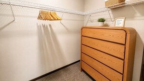A walk-in closet with a wooden dresser, a metal drying rack, and a small potted plant. - Stylish 2BR Tacoma Stay | Near Hospitals & Tacoma Dome (Tacoma)