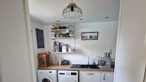 Ein kleiner Hauswirtschaftsraum mit Waschmaschine, Trockner und einem Schrank.