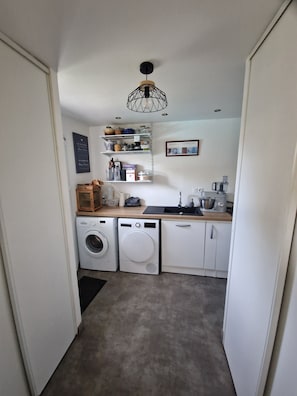 Ein kleiner Hauswirtschaftsraum mit Waschmaschine, Trockner und einem Schrank.