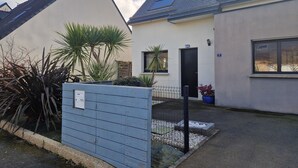 Ein Wohngebäude mit geneigtem Dach, einer sichtbaren Tür und einem kleinen Fenster.
