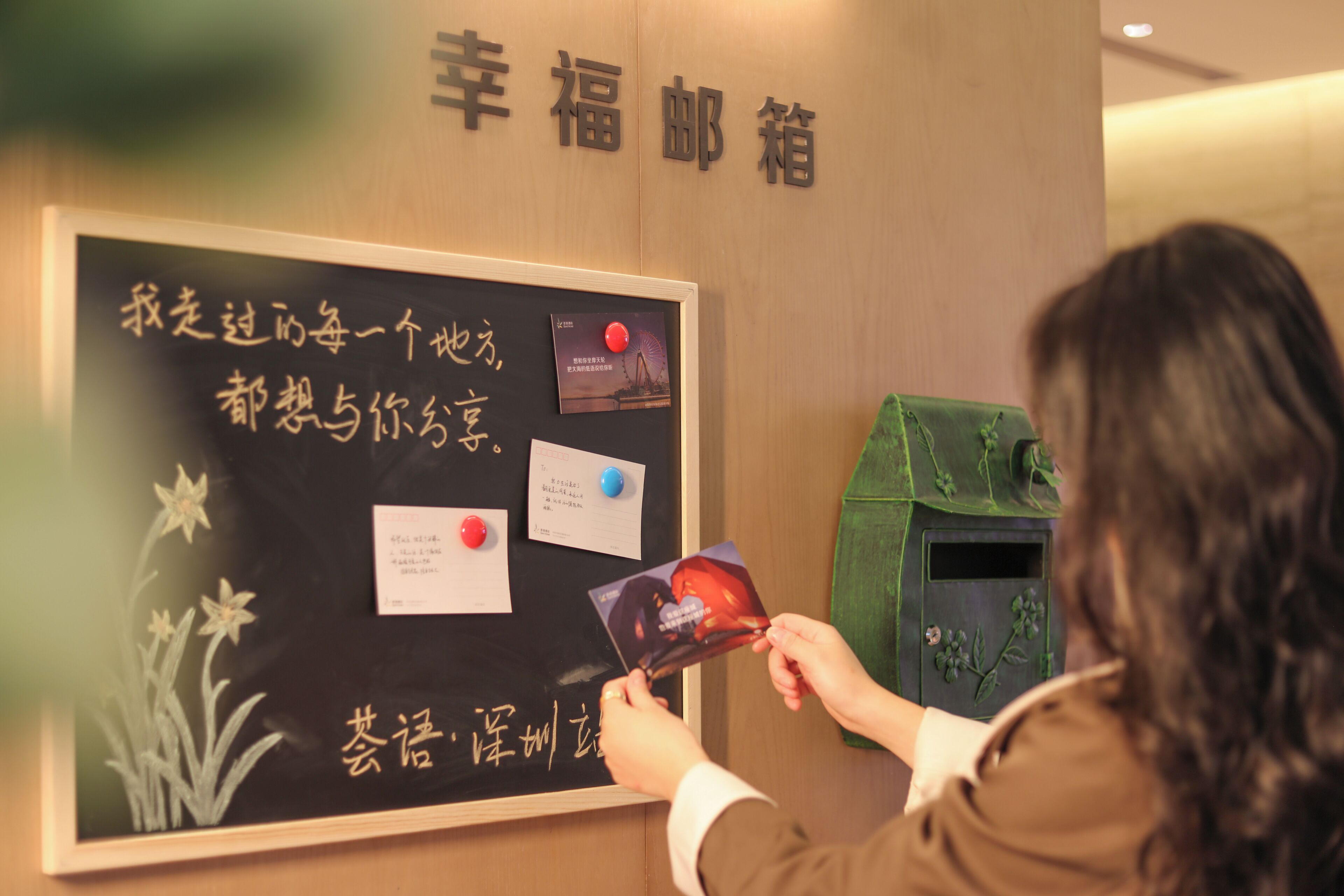A person interacting with a wall-mounted information board with text and cards.