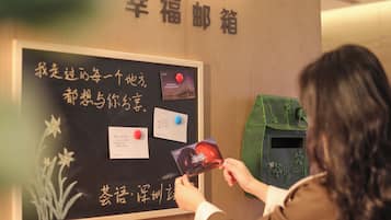 Una persona interactuando con un panel informativo fijado a la pared, con texto y tarjetas.