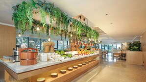 A buffet area with a variety of dishes, a coffee station, and hanging plants.