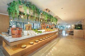 A buffet area with a variety of dishes, a coffee station, and hanging plants.