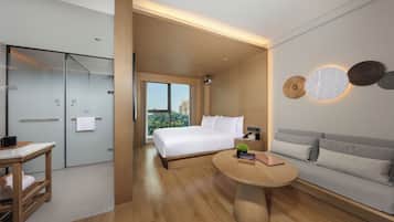 Una habitación de hotel moderna con una cama, un sofá, una mesita y un escritorio.
