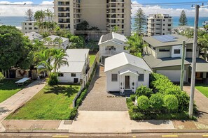A residential area with houses, a paved driveway, and a view of the ocean. - Coolum Beach Coastal Retreat- Sleeps 10 (Coolum Beach)