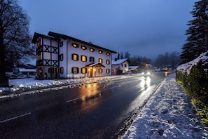 A two-story building with a snow-covered ground, a paved road in front, and a clear sky. - Grünstein Vacation Rental, 53 square meters (Schönau am Königssee)