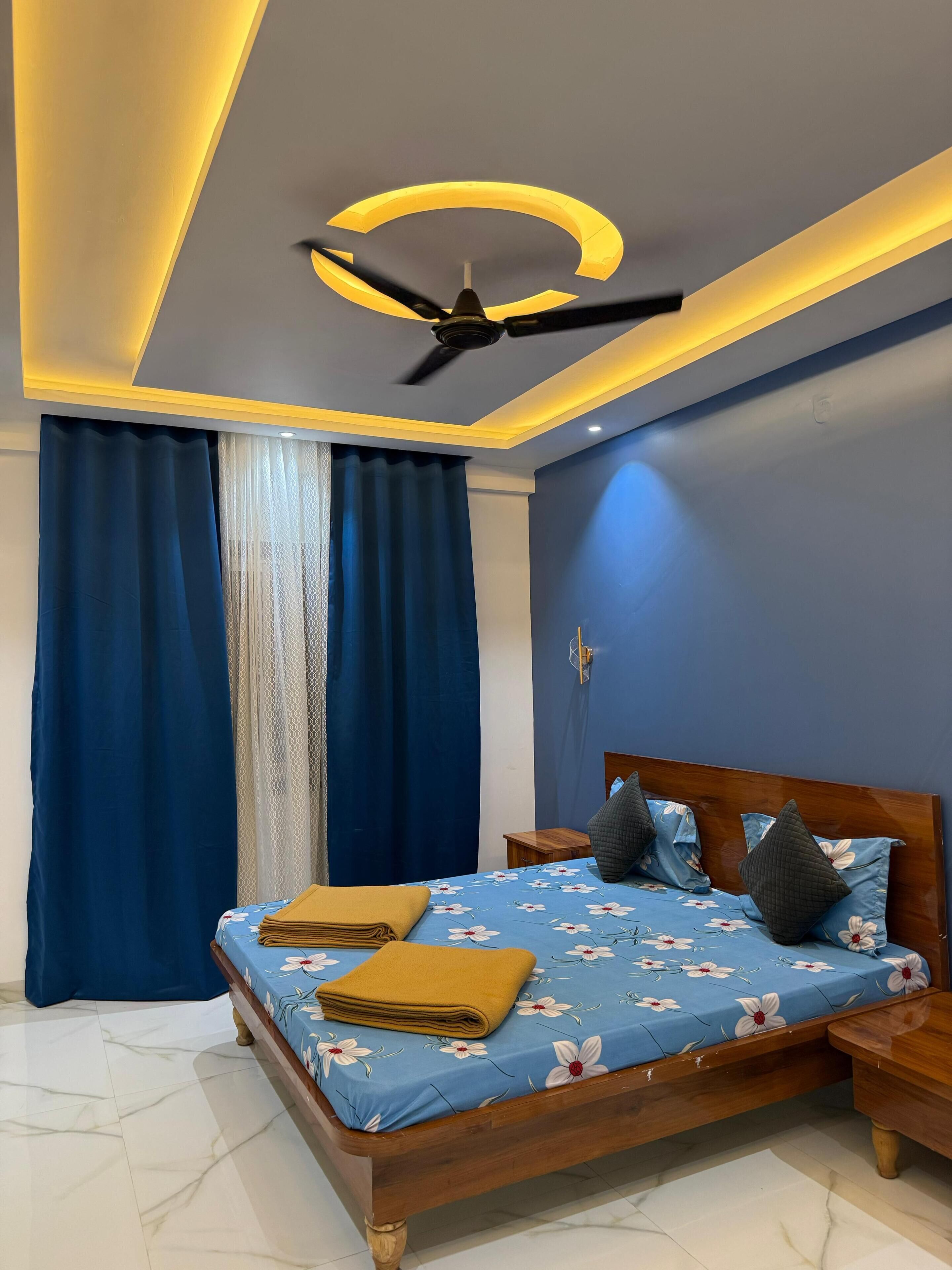 Un dormitorio con cama, ventilador de techo y mesita de noche.