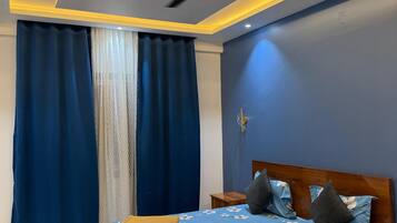 Un dormitorio con cama, ventilador de techo y mesita de noche.