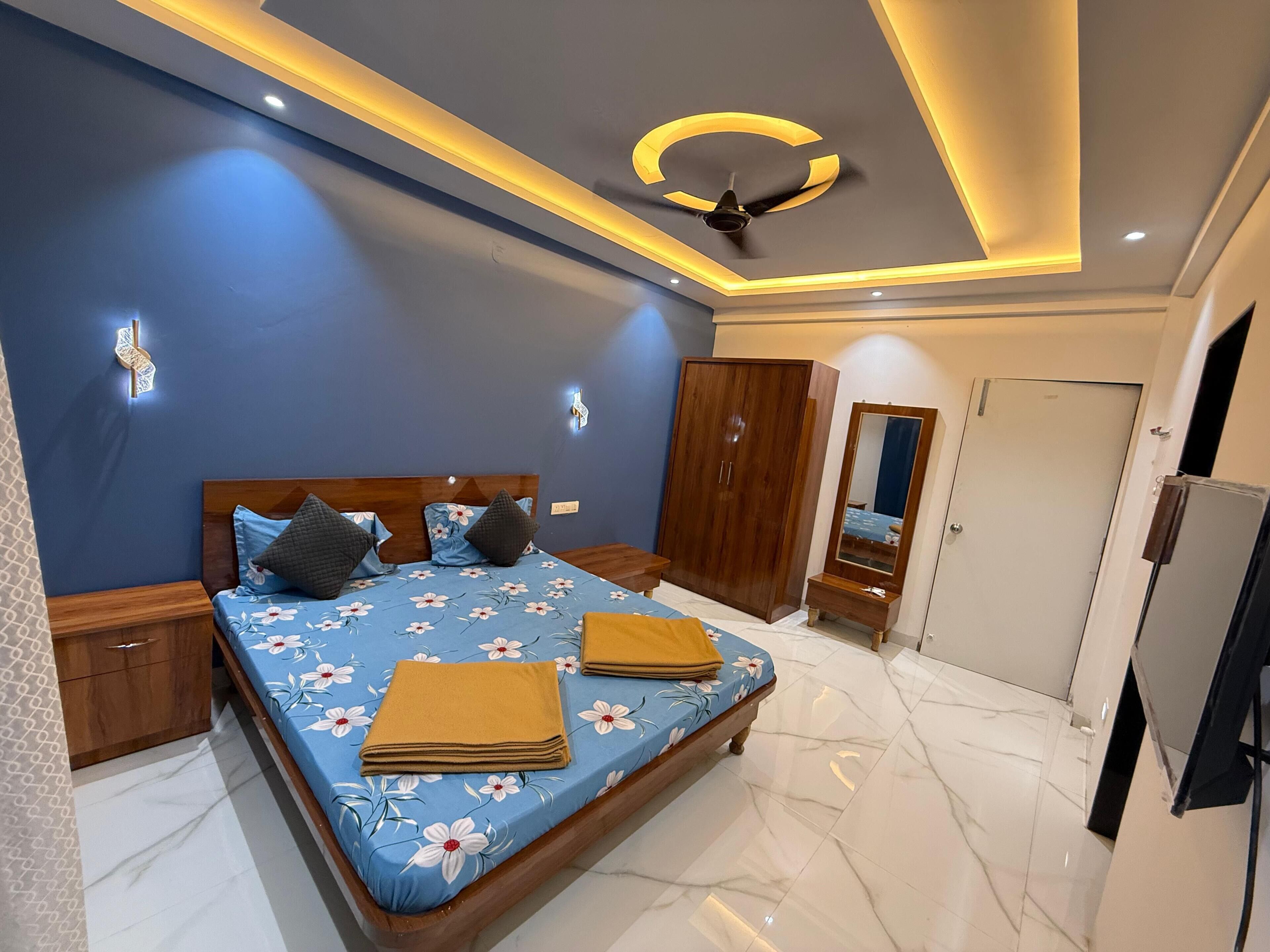 A bedroom with a bed, wardrobe, mirror, and ceiling fan.