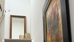 Een trap met een leuning en een aan de muur bevestigd fotolijstje.