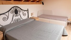 A bedroom with a bed, a bedside table, and a nightstand. - Terre di Monacella (Santa Venerina)