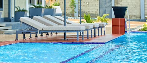A swimming pool with lounge chairs and a canopy.