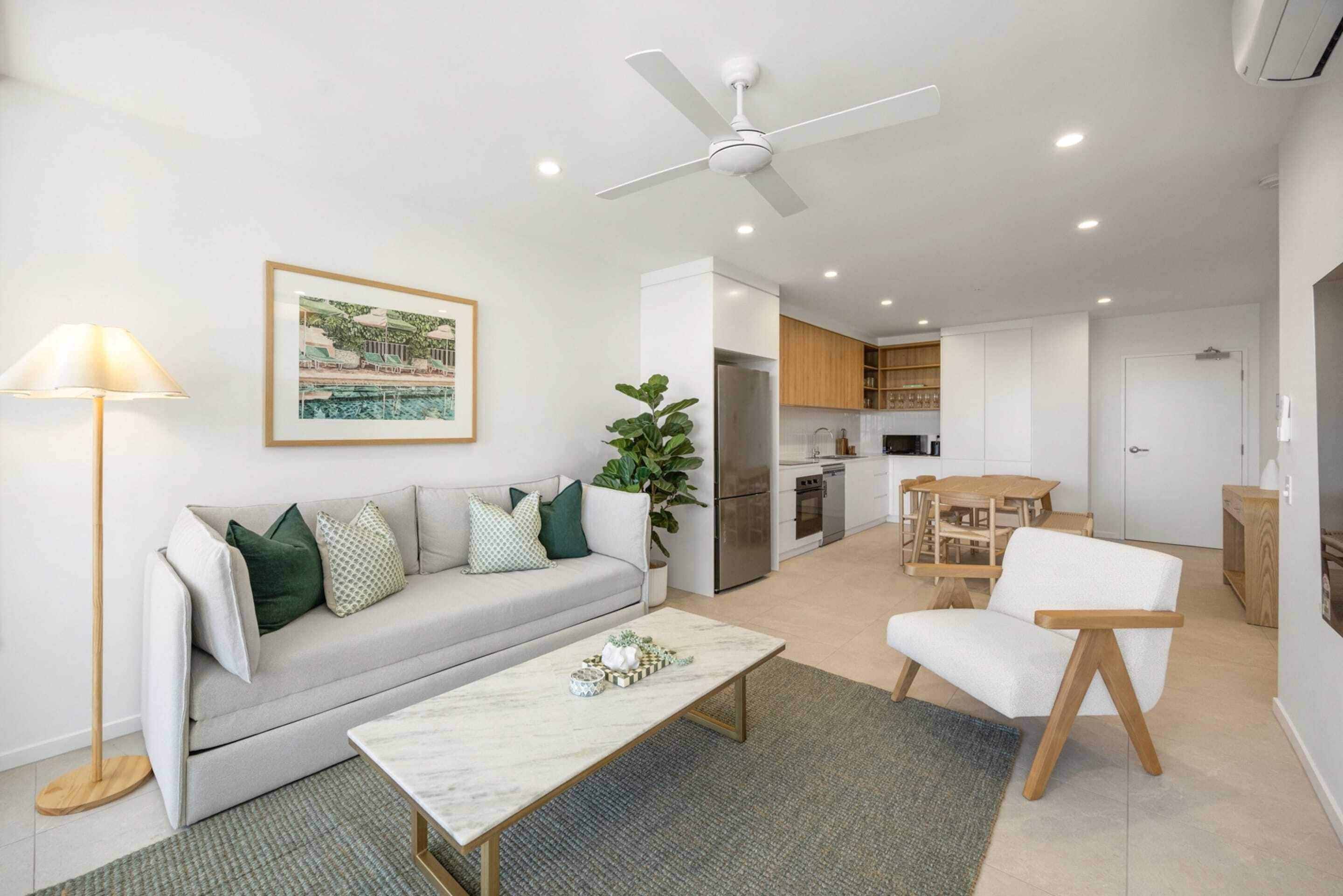 A modern living room with a sofa, coffee table, and a ceiling fan.