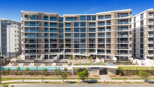 A multi-story residential building with balconies, a swimming pool, and a landscaped area. - Poolside 2-bed Apartment at Lake Kawana (Sunshine Coast)