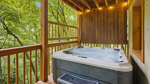 A hot tub on a wooden deck with a view of trees. - Bear Run Getaway | Near Downtown Gatlinburg (Gatlinburg)