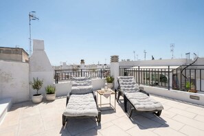 A rooftop terrace with two lounge chairs, a small table, and potted plants. - ALL Casa Tino – 3 Bedrooms & 2 Modern Bathrooms (Polignano a Mare)
