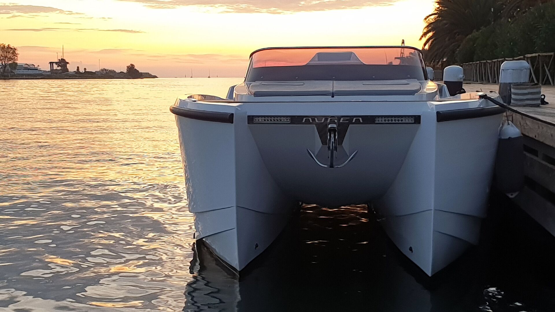 Een boot afgemeerd in een jachthaven, met een zonsondergang op de achtergrond.