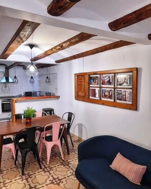 A dining area with a wooden table, chairs, and a blue sofa.