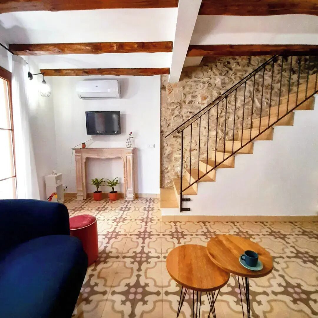 A living room with a sofa, a fireplace, a television, and a staircase.