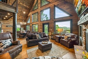 Ein geräumiges Wohnzimmer mit hohen Decken, großen Fenstern und einem Kamin.